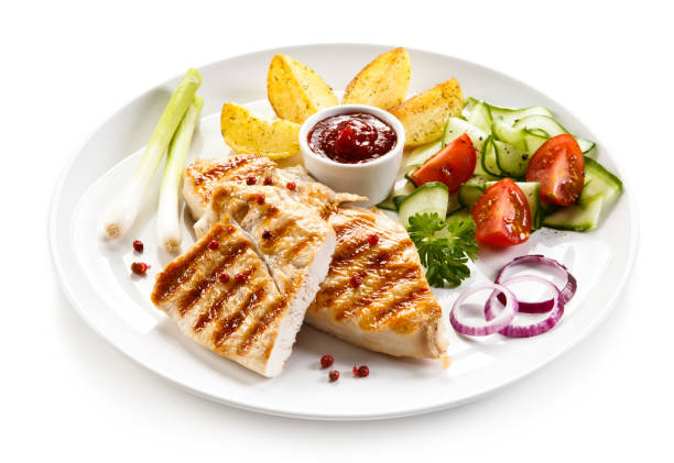 istock Grilled chicken breast and vegetables on white background 1044856720
