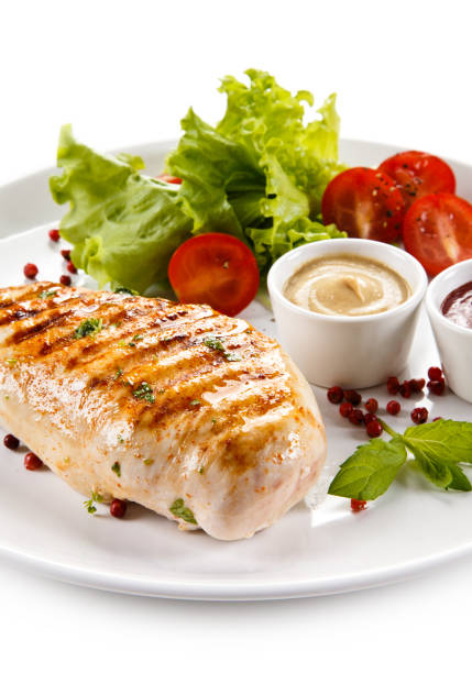 istock Grilled chicken breast and vegetables on white background 1044860014