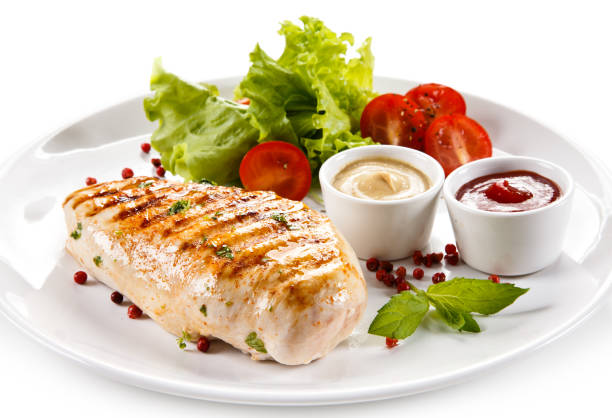 istock Grilled chicken breast and vegetables on white background 1044860276