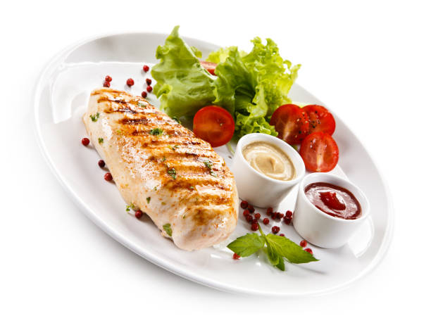 istock Grilled chicken breast and vegetables on white background 1044860360