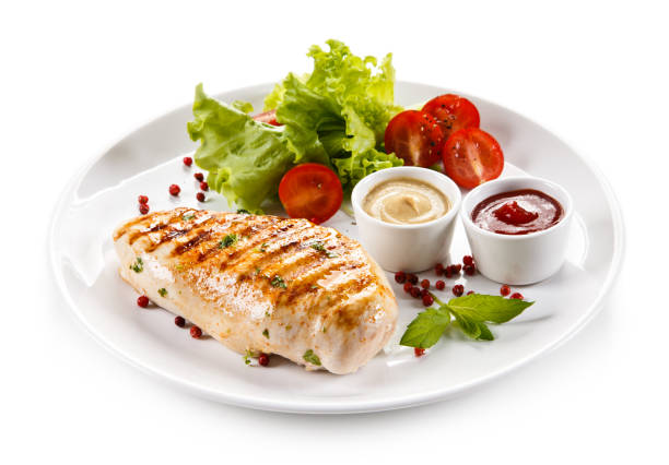 istock Grilled chicken breast and vegetables on white background 1044860622