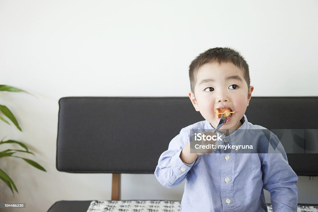 Japanese child eating on couch Children eat a donut Child Stock Photo