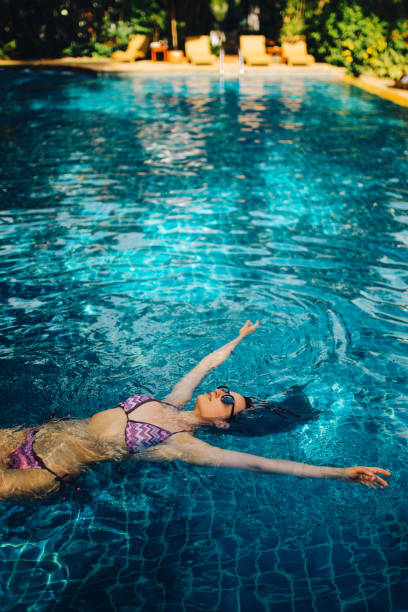istock Young woman relaxing in the pool 1044865980