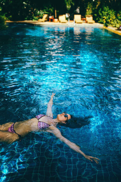 istock Young woman relaxing in the pool 1044866382
