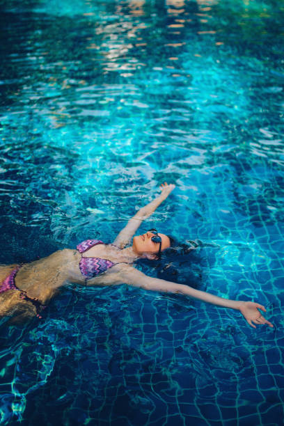 istock Young woman relaxing in the pool 1044866520