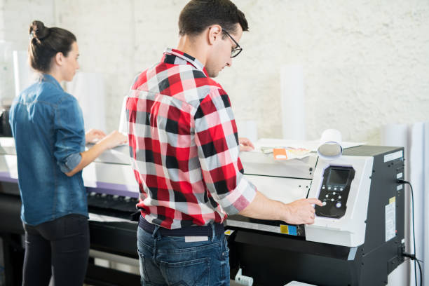istock Man and woman using printing equipment 1044866804