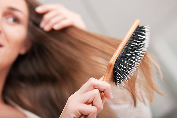 mujer joven cepillar el cabello - hair care combing women human hair fotografías e imágenes de stock