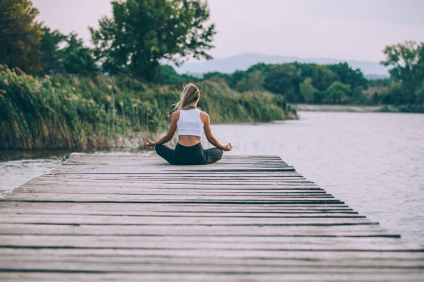 istock Girl meditating by the water 1044870258
