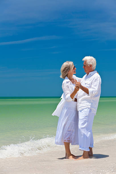 istock Happy Senior Couple Dancing Holding Hands on A Tropical Beach 104487152