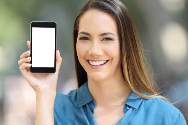 istock Girl looking at camera showing a smart phone screen 1044875422