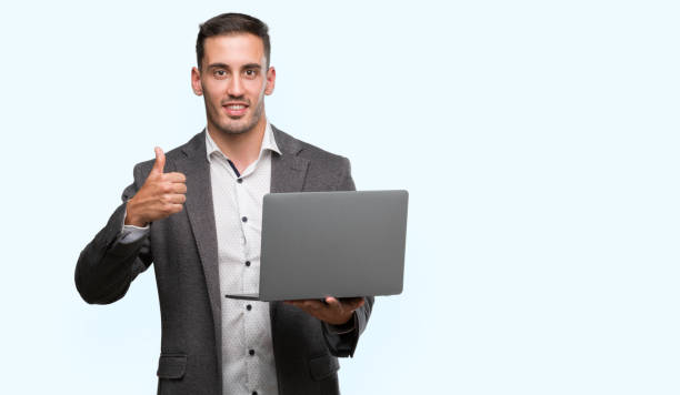 istock Handsome young man using computer laptop happy with big smile doing ok sign, thumb up with fingers, excellent sign 1044876176