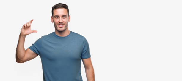istock Handsome young casual man smiling and confident gesturing with hand doing size sign with fingers while looking and the camera. Measure concept. 1044879664