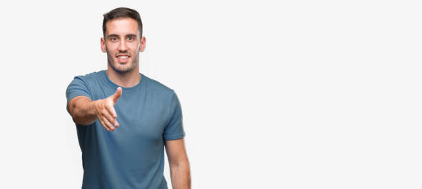 istock Handsome young casual man smiling friendly offering handshake as greeting and welcoming. Successful business. 1044880090