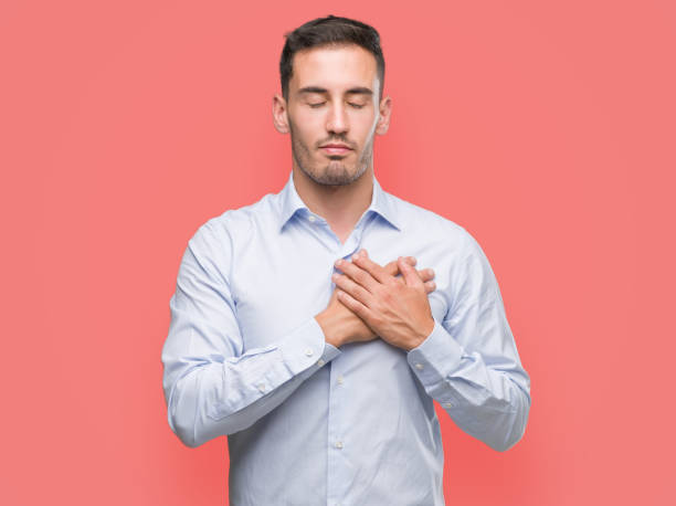 istock Handsome young businessman smiling with hands on chest with closed eyes and grateful gesture on face. Health concept. 1044880452