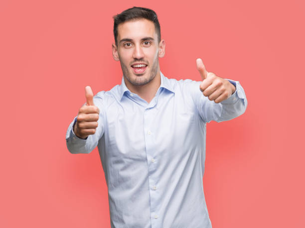 istock Handsome young businessman approving doing positive gesture with hand, thumbs up smiling and happy for success. Looking at the camera, winner gesture. 1044880456