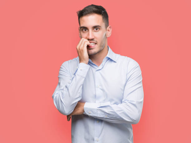 istock Handsome young businessman looking stressed and nervous with hands on mouth biting nails. Anxiety problem. 1044880532