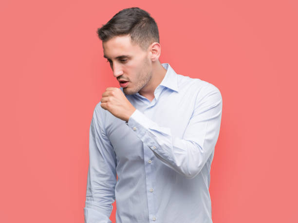 istock Handsome young businessman feeling unwell and coughing as symptom for cold or bronchitis. Healthcare concept. 1044880550