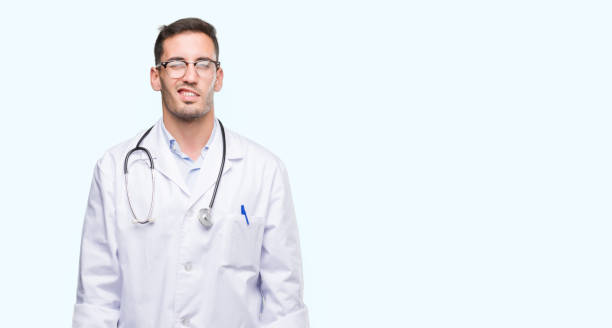 istock Handsome young doctor man winking looking at the camera with sexy expression, cheerful and happy face. 1044883192