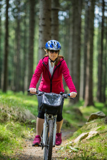 istock Woman riding bike on forest trails 1044888416