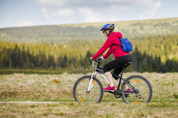 istock Woman riding bike on forest trails 1044894732