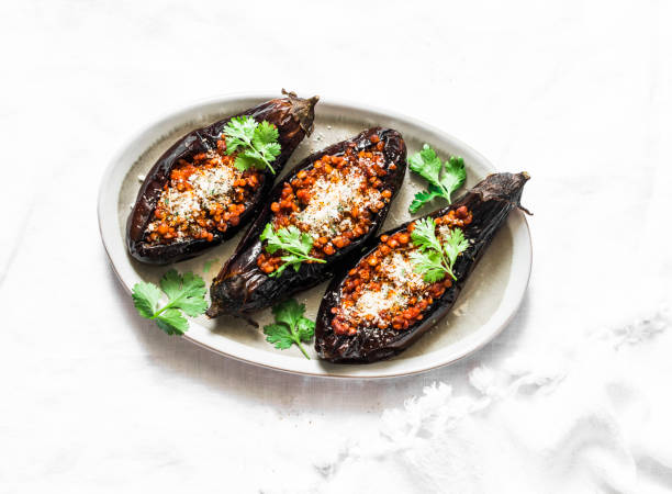 Stuffed tomato sauce lentils roasted eggplant - delicious healthy vegetarian food lunch. On a light background, top view