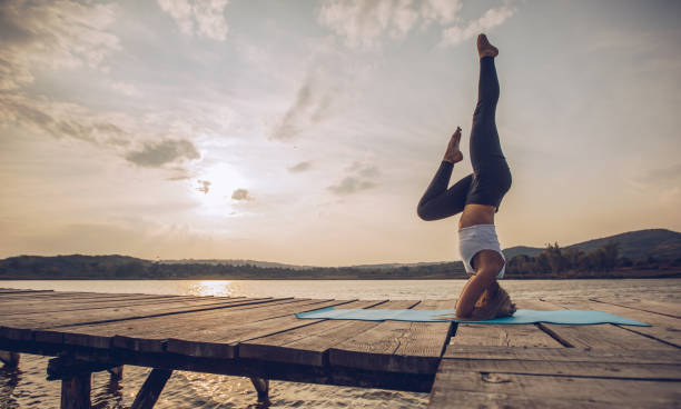 istock Yoga exercise by the lake in sunset 1044907816