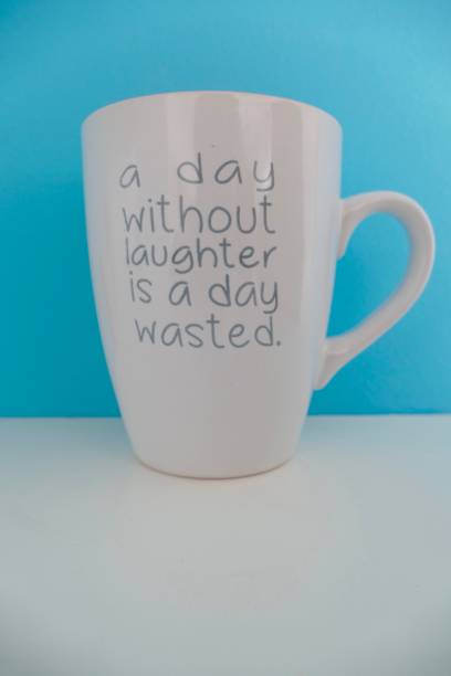 istock White cup with quotation - A day without laughter is a day wasted - on blue background 1044908234