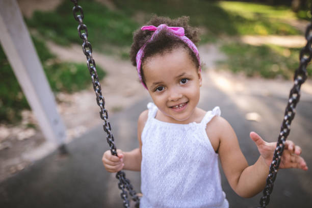 istock Lovely smiling girl swinging on a swing 1044915826