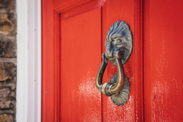 закройте львиную голову дверь стук на ярко-красной двери. - front door door red red door стоковые фото и изображения