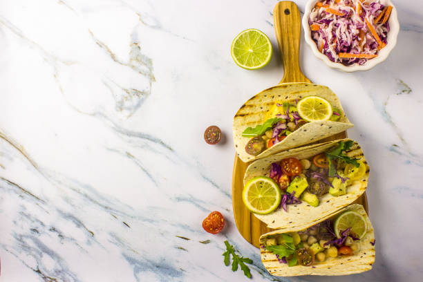 istock Healthy corn tortillas with chickpeas, tomatoes, avocado, fresh arugula, limes 1044938770