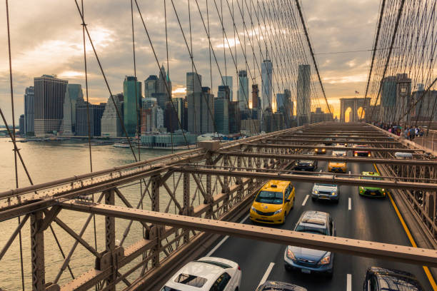 manhattan mit brooklyn bridge im vordergrund bei sonnenuntergang - taxi new york city traffic busy stock-fotos und bilder