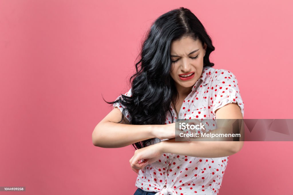Young woman scratching her itchy arm. Young woman scratching her itchy arm. Skin problem. Skin Stock Photo
