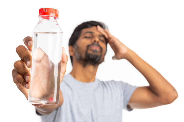 istock Focused water bottle held my man touching forehead 1044939380
