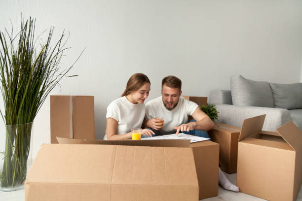 istock Happy spouses discussing house blueprint drinking juice 1044943362