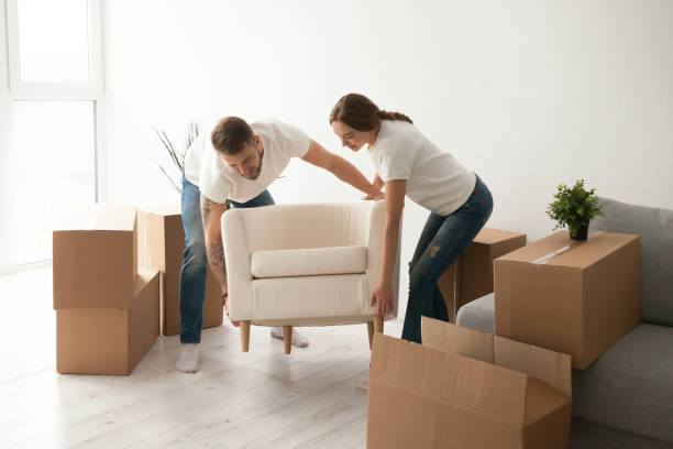 istock Young couple carrying chair to first shared apartment 1044943374