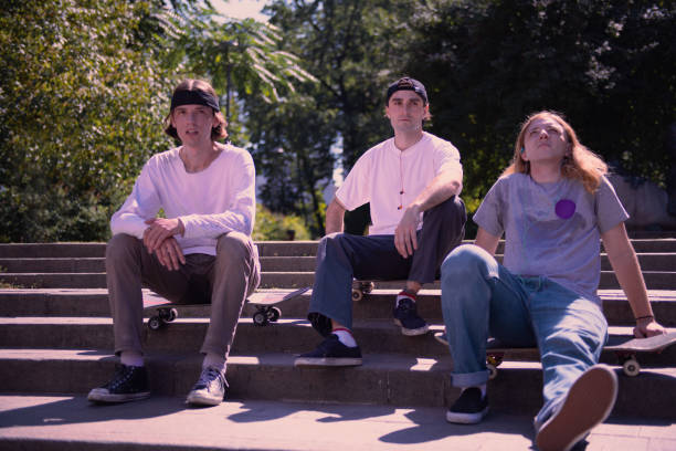 istock Relaxed brunette males sitting on their skateboards 1044943798