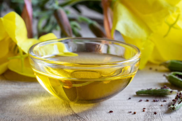 istock Evening primrose oil with fresh evening primrose flowers 1044946654
