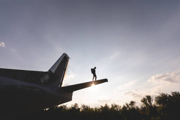 istock Athletic parachuter standing on a airplane wing in sunset 1044949910