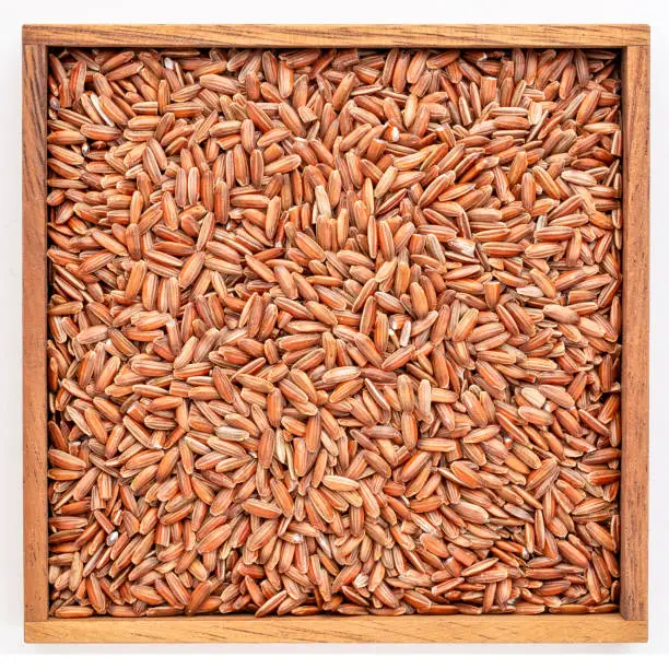 brown rice grain in an isolated wooden box