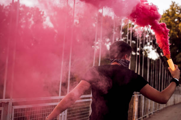 istock Young Man Holding A Smoke Bomb 1044950348