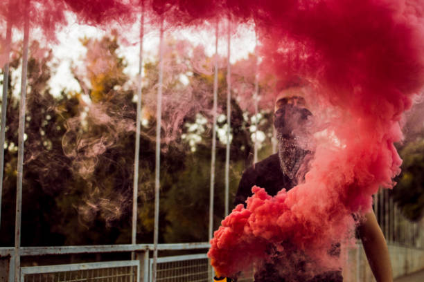 istock Young Man Rebel With Smoke Bomb In His Hand 1044950438