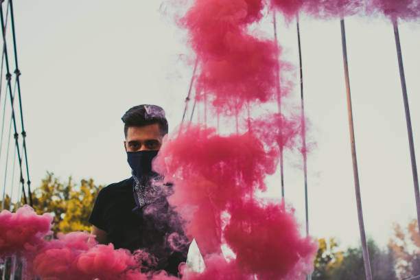 istock Young Man Holding A Smoke Bomb 1044950550
