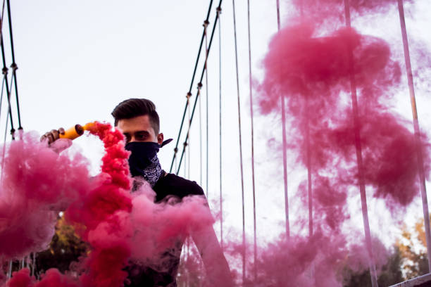 istock Young Man Holding A Smoke Bomb 1044950584