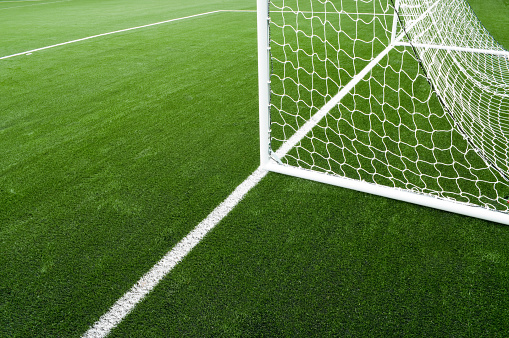 Soccer net and field on bright green artificial turf.