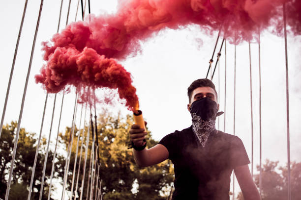 istock Young Man Rebel With Smoke Bomb In His Hand 1044955034
