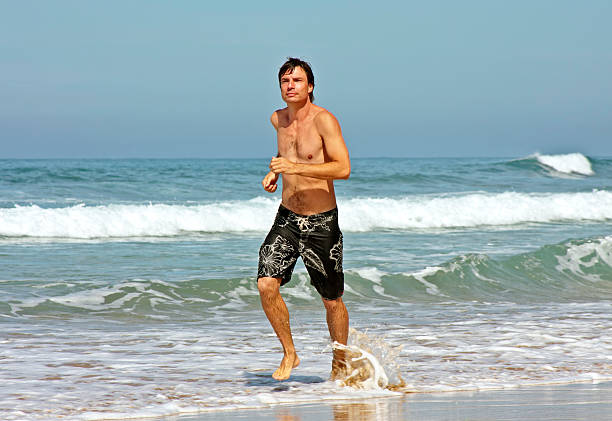 istock Young man jogging on the beach 104495825