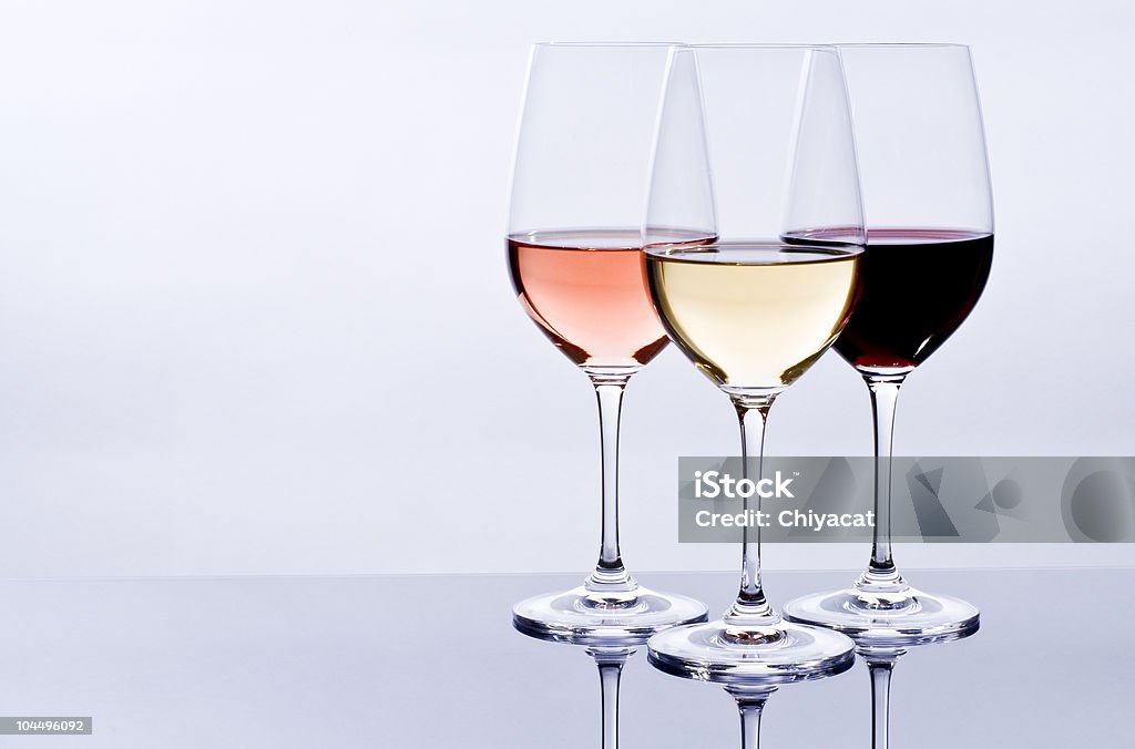 Three wine glasses filled with colorful wine Elegant crystal wine glasses filled with red, pink and white wine. Wine Tasting Stock Photo