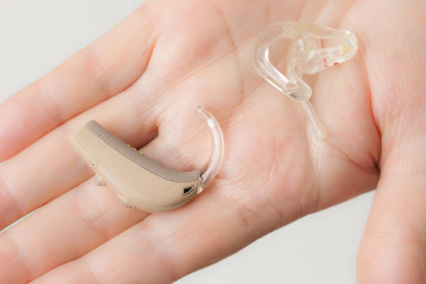 istock senior person holding hearing aid closeup 1044961354