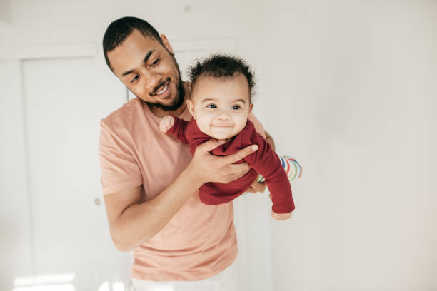 Emotional attachment between baby and dad Dad is smiling at his cute daughter. father and baby stock pictures, royalty-free photos & images