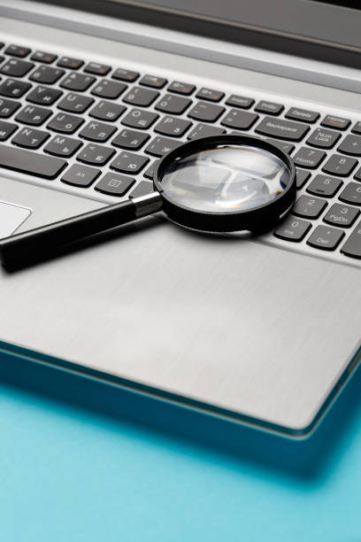 istock Laptop computer with magnifying glass on blue background, concept of search. Internet security conceptual image. 1044969032